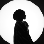 Home Silhouette of a woman in traditional attire against a bright circular backdrop. Elegant and mysterious.